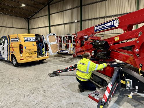 Engineer with a yellow access platform and white van